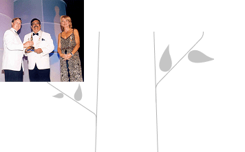 Man receiving an award on stage with presenters during a formal ceremony